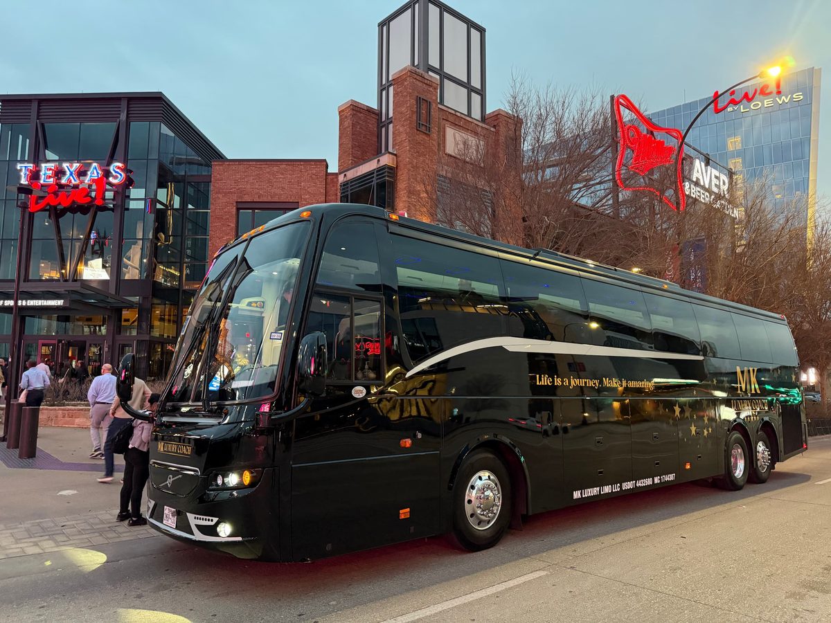 MK Luxury Coach black motor coach at Texas Live! Arlington evening event