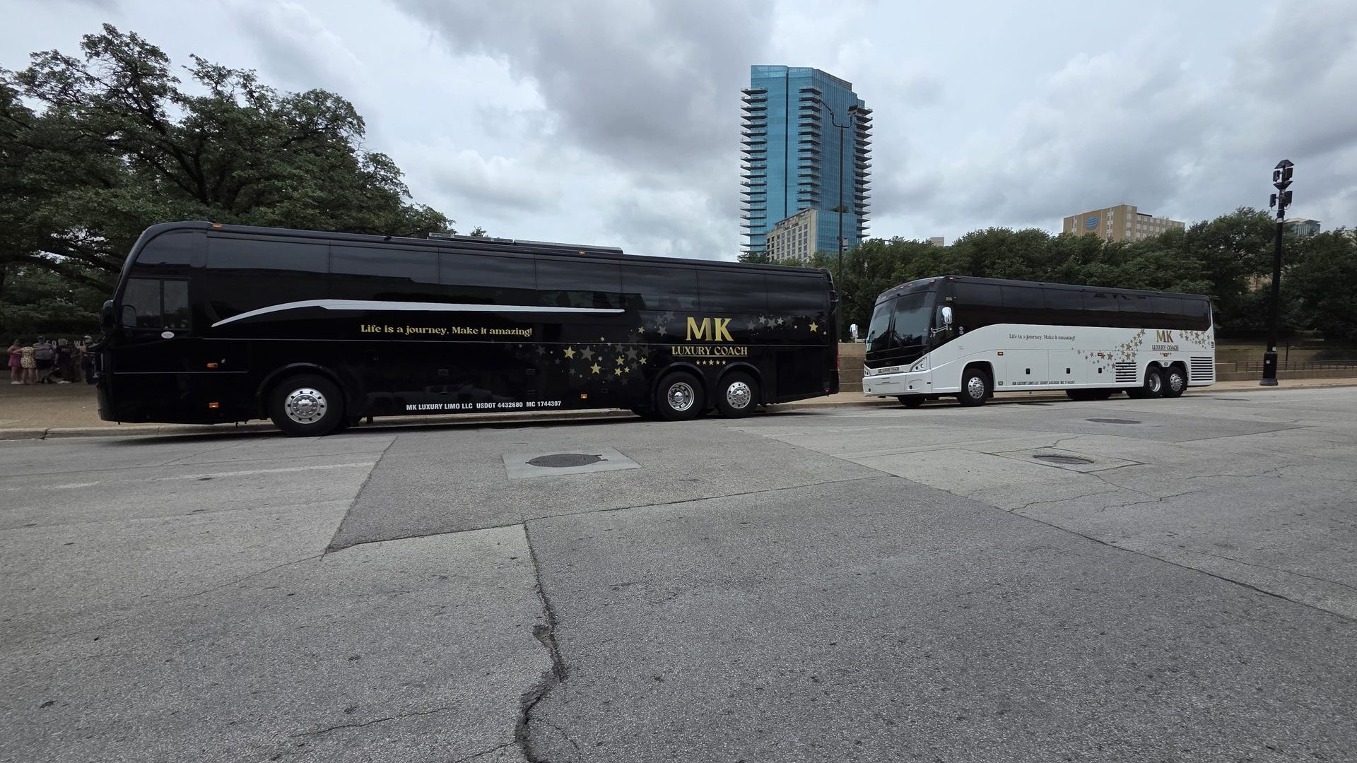 MK Luxury Coach motor coaches parked with the Dallas skyline behind them