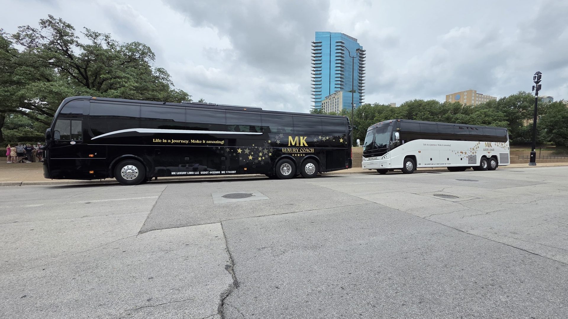 Two MK Luxury Coach motor coaches on a Dallas street