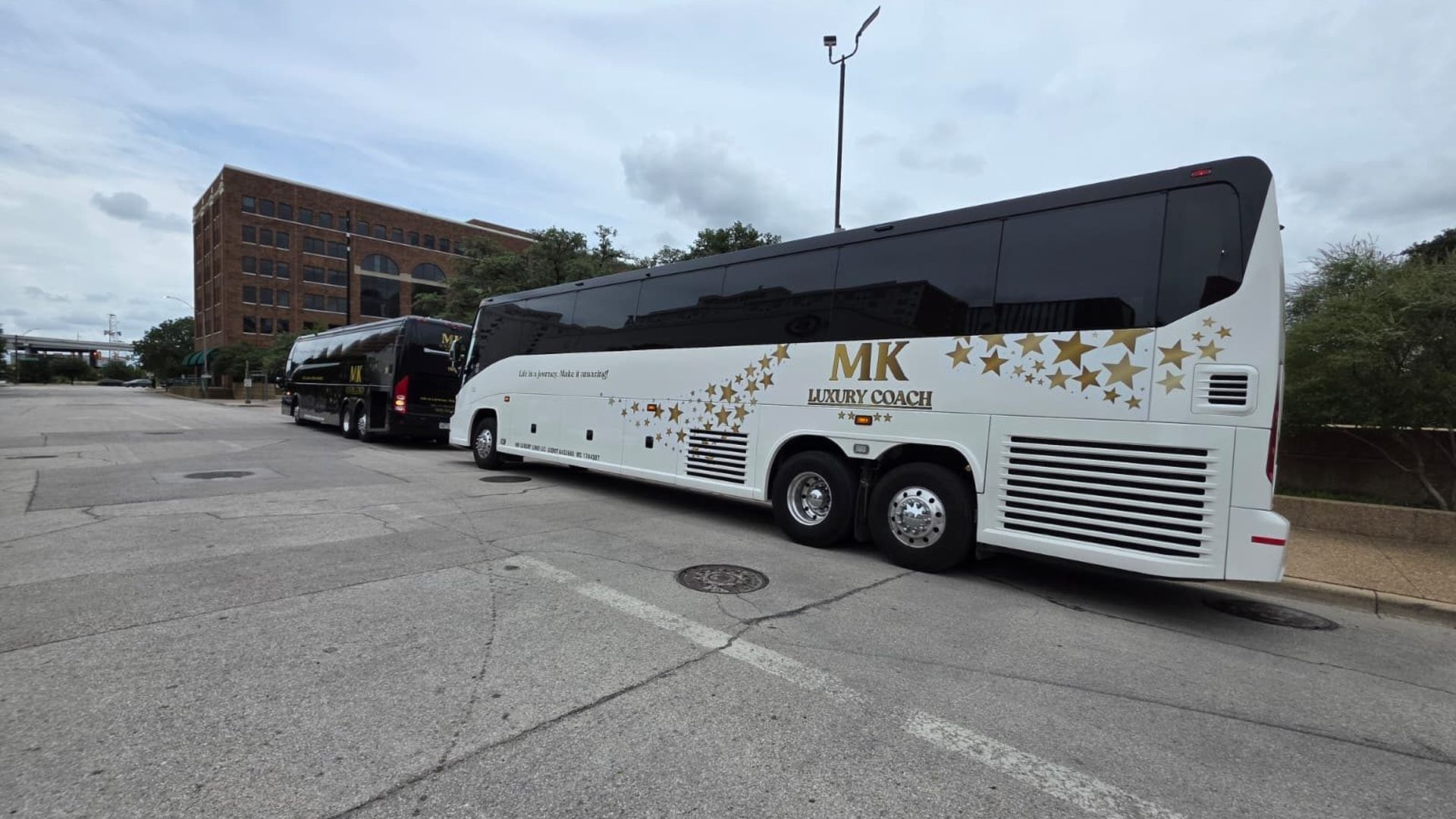 Rear view of MK Luxury Coach motor coaches lined up before departure